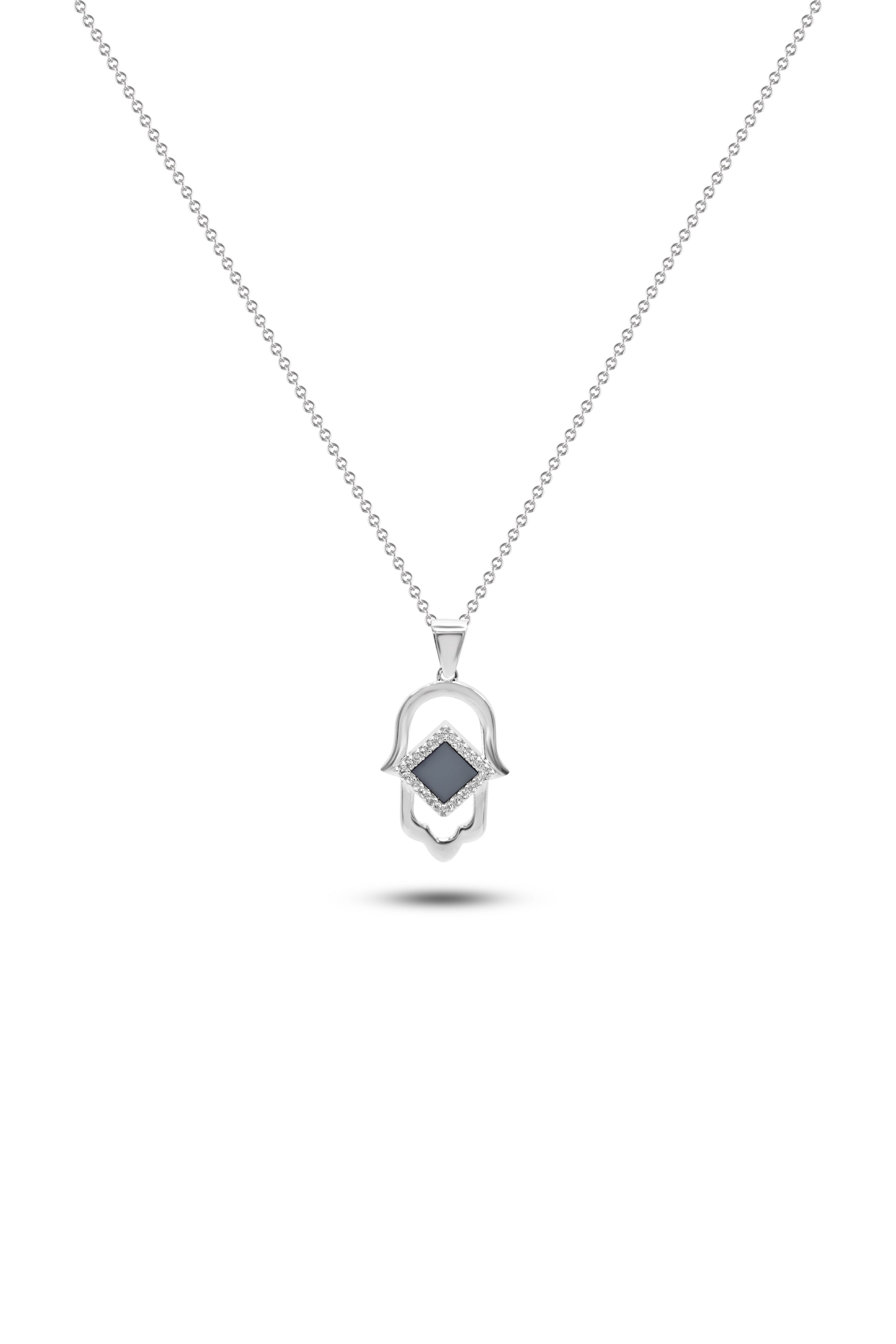 The Hamsa Necklace | Old Testament Edition features a delicate silver chain with a Hamsa hand pendant, accented by a central black geometric stone and fine detailing, shown on a white background—a unique Nano Jewelry piece.