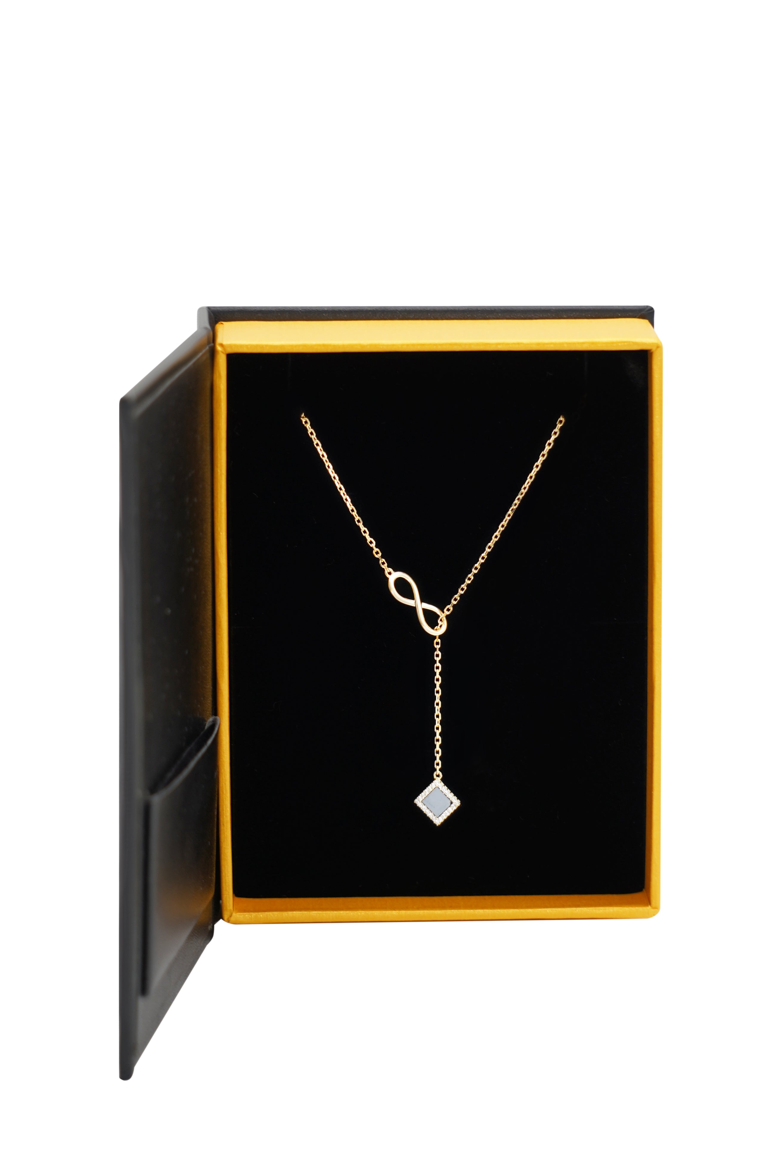 The Infinity Necklace- Old Testament Edition, a gold piece with an infinity symbol and square pendant, ideal as nano Christian jewelry, is shown in an open black and yellow box against a white background.