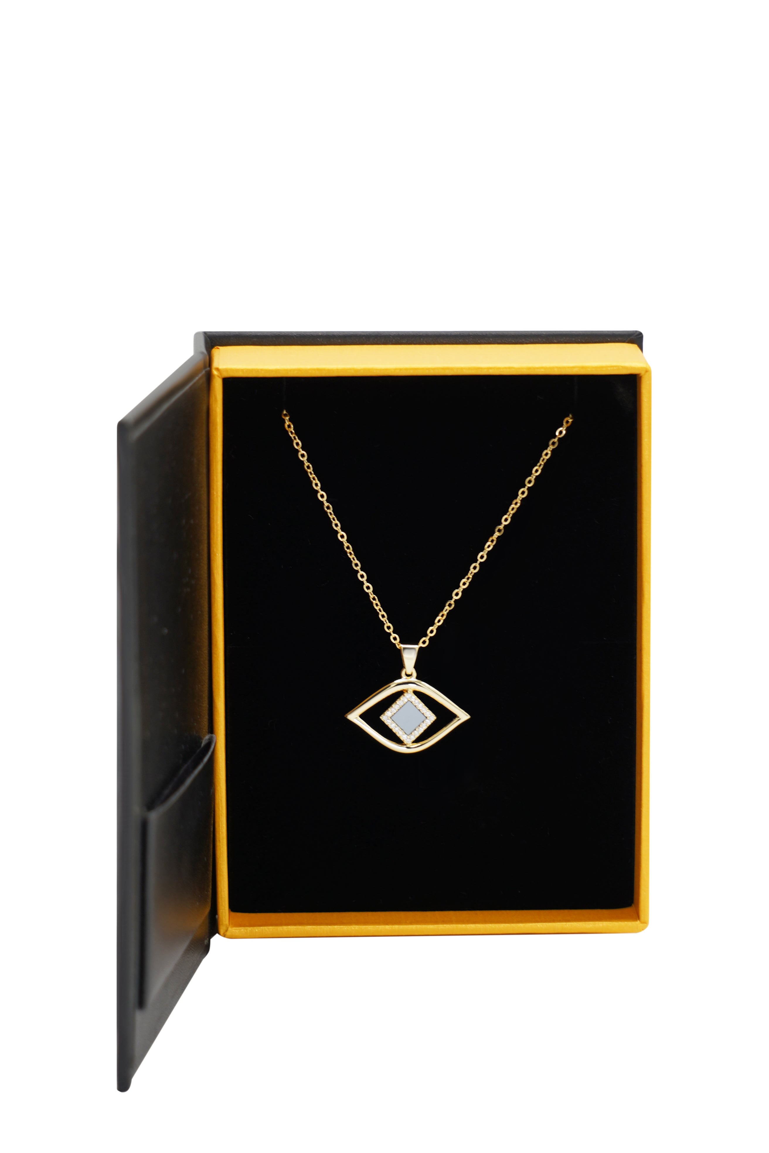 The Eye Necklace features a gold, eye-shaped pendant with a central nanochip, presented in an open black and gold jewelry box with a black velvet interior—a refined piece of nano jewelry.